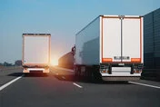 行驶中的白色铰接式货车，是陆路高效货运和物流的理想选择。