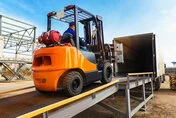 在动态建筑工地上使用的高效橙色叉车，针对重型货物和物流要求进行了优化。